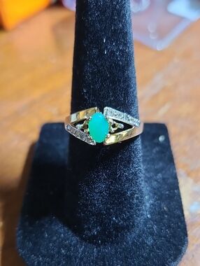Yellow gold over sterling silver ring with a green cabochon stone with diamonds.